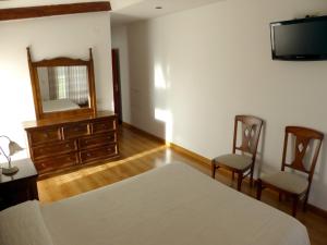 Vitigudino拉托尔托拉度假屋的一间卧室配有一张床、梳妆台和镜子