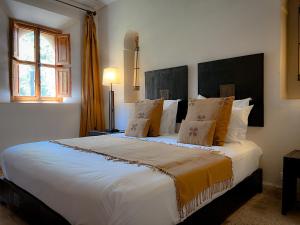 Oulad Mazoug迈丹艾尔艾尔莎旅馆的卧室配有带枕头的大型白色床