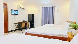 贡布Kampot Coco Guest House的酒店客房设有两张床和一张桌子。