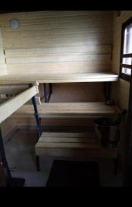 科沃拉Saaramaa Camping的木制桑拿房,配有长凳和桶