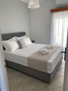 Glyfada FokidasSeaside Apartment in Glyfada-Trizonia的卧室配有一张带白色床单和枕头的大床。