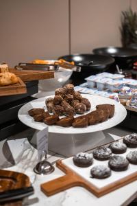 普里什蒂纳Hotel MANAMI的一张桌子,上面放着两盘饼干和其他糕点