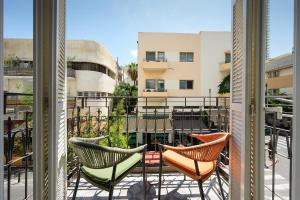 特拉维夫Alberto by Isrotel Design的阳台配有椅子,享有建筑的景致。