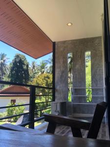 班泰Yangyai Garden Lodge的客房设有带桌子和长凳的阳台。