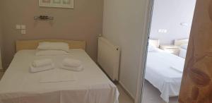 帕拉西亚斯Achilleas Apartments的一间卧室配有一张带两条白色毛巾的床