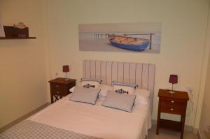戈梅拉岛圣塞瓦斯蒂安Apartamento en Casco Histórico的卧室配有一张床,墙上有一条船