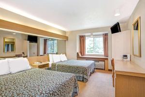 斯特布里奇Days Inn by Wyndham Sturbridge的酒店客房设有两张床和窗户。