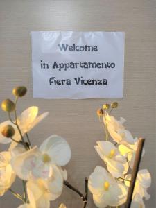 维琴察Appartamento Fiera Vicenza的墙上的标志,上面有白色的花