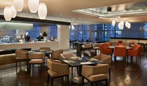 迪拜迪拜艾尔里加凯悦酒店的一间带桌椅的餐厅和一间酒吧