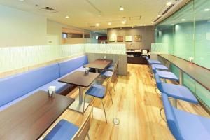 大阪Best Western Osaka Tsukamoto的餐厅设有木桌和蓝色椅子
