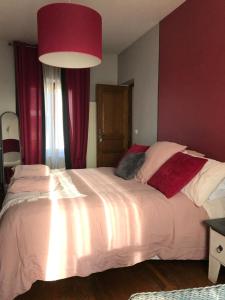 拉图尔德萨尔瓦尼LA MAISON D'IVONA的卧室配有一张带红色窗帘的大型白色床