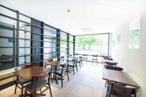 札幌Best Western Sapporo Odori Koen的用餐室设有桌椅和窗户。