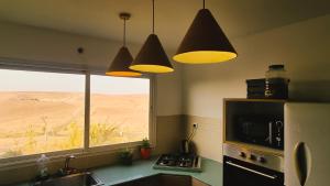 阿拉德Olives的厨房设有窗户和三盏吊灯