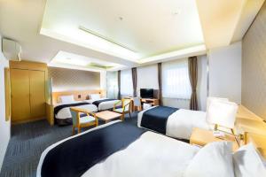 大阪SureStay Plus Hotel by Best Western Shin-Osaka的酒店客房配有两张床和一张书桌