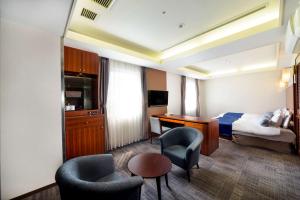 大阪SureStay Plus Hotel by Best Western Shin-Osaka的酒店客房,配有一张床、一张桌子和椅子