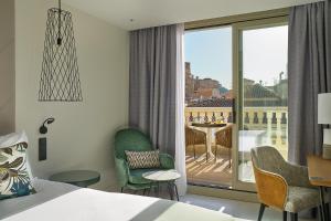 马拉加Vincci Larios Diez的酒店客房设有一张床,享有阳台的景色