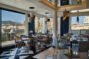 马拉加Vincci Larios Diez的餐厅设有桌椅和大窗户。