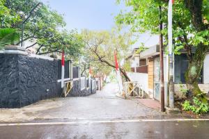 万隆OYO 91561 Gandhi Hotel的一条空的街道,有栅栏,树木和建筑物