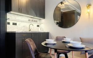奥尔什丁DK Premium Mendelsohna的厨房配有桌椅和镜子