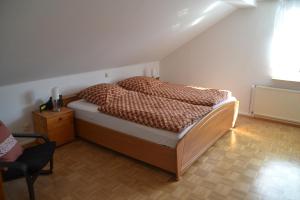弗兰克瑙Frankenau Fewo Kellerwald的卧室配有床、椅子和窗户。
