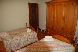 雷诺萨Apartamentos La Luz de Reinosa 2的一间卧室设有两张床和木制橱柜