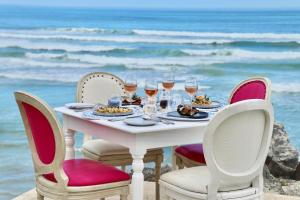 赫曼努斯伯肯黑德酒店的海滩上一张桌子,上面放着食物和酒杯