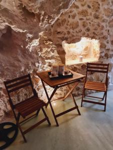 海若克利欧Anassa Cave by Estia的洞穴里的一张木桌和两把椅子