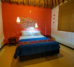 亚美尼亚Hotel Campestre Solar De La Luna的一间卧室配有一张橙色墙壁的床