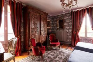 多维尔图尔热维尔狮子庄园酒店的一间带红色椅子的卧室和大型木制橱柜
