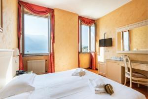 利莫内-苏尔加达Hotel Le Palme的卧室配有一张床、一张书桌和窗户。