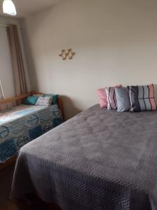 圣佩德罗-达阿尔德亚Apartamento Cobertura的一间卧室配有一张床和长凳