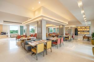 艾哈迈达巴德Vivanta Ahmedabad SG Highway的用餐室设有桌椅和窗户。