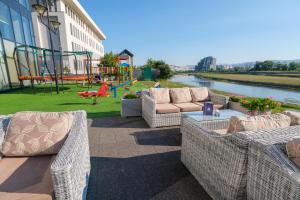 萨拉热窝马拉克丽景湾酒店的一个带2张柳条沙发和游乐场的庭院