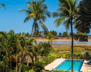 圣米格尔-杜戈斯托苏普萨达维拉巴卡娜酒店的拥有游泳池、棕榈树和河流的度假胜地
