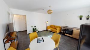诺伊鲁平Travel Art Boardinghouse (Lazarettstr.)的客厅配有白色桌子和黄色椅子