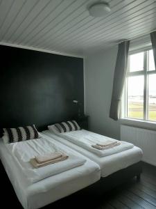侯尔马维克Gistihús Hólmavíkur的卧室设有两张单人床和窗户。