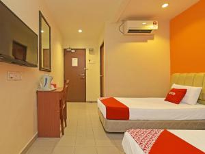 新山OYO 90510 Hotel Sahara的酒店客房带两张床和一间浴室