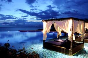 美奈Centara Mirage Resort Mui Ne的度假村,带一张床,晚上带大海