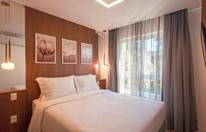 格拉玛多Cityhome Bav Residenz Gramado的一间卧室设有一张大床和一个窗户。