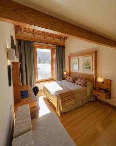 圣马丁德洛斯村舍酒店的一间卧室设有两张床和大窗户
