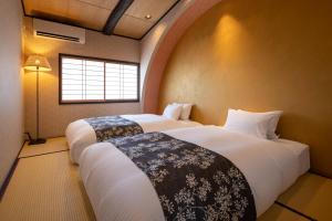 京都京恋 黄金屋的带窗户的客房内的两张床