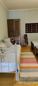 梅斯蒂亚Village House的一间卧室配有一张床和地毯