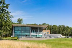 波克灵顿The Kilnwick Percy Resort and Golf Club的一座带玻璃窗和草地的大型建筑