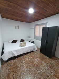 波帕扬KOMODO ALOJAMIENTO- hostal autoservicio y ubicado muy cerca al centro histórico -habitaciones con baño privado, wifi , cama 2x2的一间卧室设有一张床和木制天花板