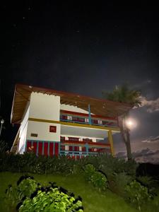 贾丁Cabaña Filo de Oro, jardín的一座晚上有棕榈树的建筑