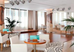 卡里拉KAKTUS Hotel Volga - Adults Recommended的客房设有白色的椅子、桌子和一些窗户。