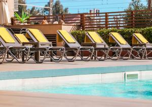 卡里拉KAKTUS Hotel Volga - Adults Recommended的游泳池旁的一排黄色躺椅