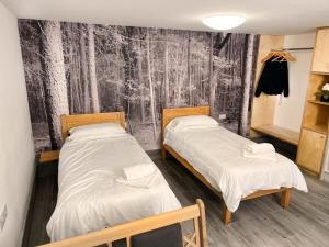 TicehurstLodges at Flimwell Park的配有黑白壁纸的客房内的两张床