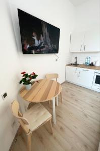 卡托维兹White Apartments - Free parking的厨房配有木桌和桌椅