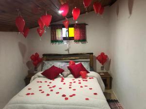 维奥康德马奥Chalé jeito de roça na Pedra Selada的卧室,卧室在带气球的床上红心